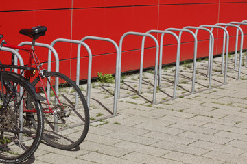 Fahrradständer aus Metall, rote Mauer, geparkte Fahrräder