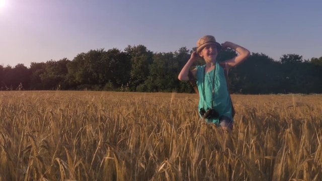 Little Girl walking in a Wheat field waving with her hand
