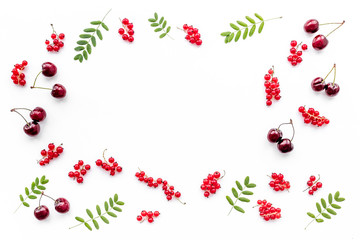Berry frame. Red currant, cherry and leaves on white background top view copyspace