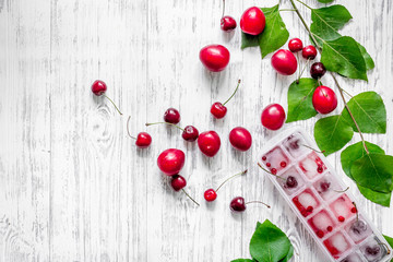 Pulm, cherry, ice for summer fruit drink on wooden table background top view copyspace
