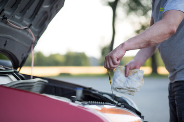 Man hands checking the oil of car motor, maintenance