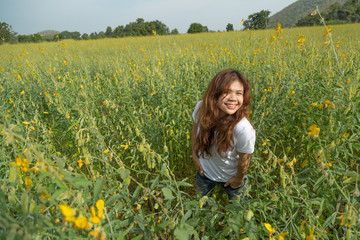 Fototapeta premium asian women with slightly curly in yellow field at summer, Thailand.