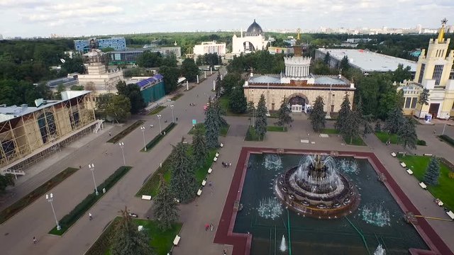 Moscow. Vdnkh. Soviet Historical Center. Beautiful Buildings on Square. Fountain in Water Pool. Green Park. People Walking. City on Background