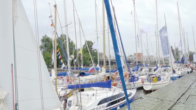 City quay. Sailing regatta. Yacht club, port. A rainy summer day. Yachts are laid up. Safe harbor, calm water. Overcast windy. People walk on the pier. Kaliningrad - July 2017 Russian.