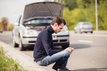 Obraz premium Man in despair because of the failure of his car