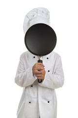Boy chef hiding his face behind the black frying pan