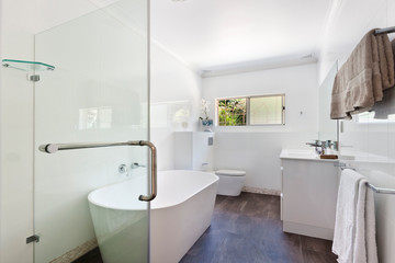 Naklejka na ściany i meble A modern bathroom with a shower area and a bathtub including a wall mirror