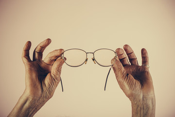 Old age glasses, woman holding glasses for sight. Eyes with problems, health and blurred vision...