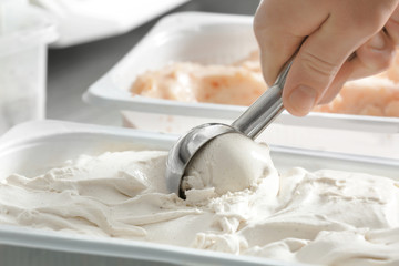 Woman taking scoop of tasty yogurt ice cream, closeup