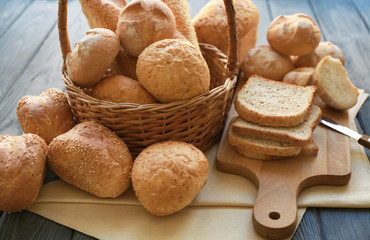 Basket with delicious bread on wooden background