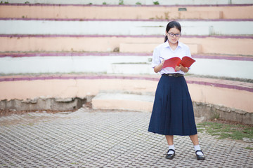 Thai student girl writing on a books at the park