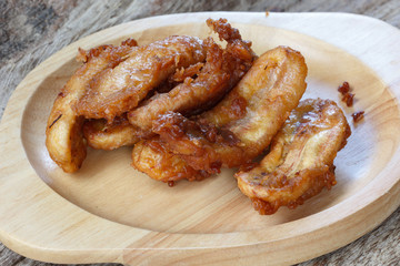 Fried banana fritters on with wood plate