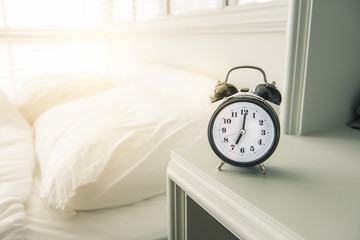 Black alarm clock in bedroom with sunlight , wakeup , morning