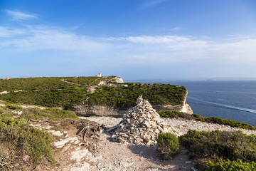 Fototapeta na wymiar Bonifacio, Corsica, France. Pyramid of stones on the beach
