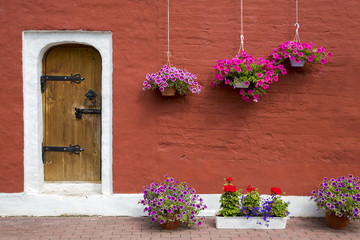 Old stone house decorated with colorful petunia flowers