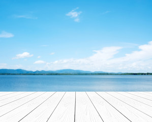 Empty perspective white wood over blur blue sea and sky background, nature background, spring and summer, tropical climate, travel concept, for product display montage