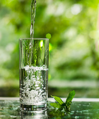 Cool fresh water with ice and mint. Splash in glass. Healthy life concept