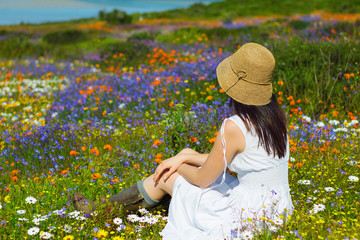 Young woman looking at spring flowers in West Coast National Park