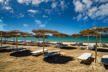 Paros island, Cyclades, Greece. Straw umbrellas and beach loungers on Golden Beach.
