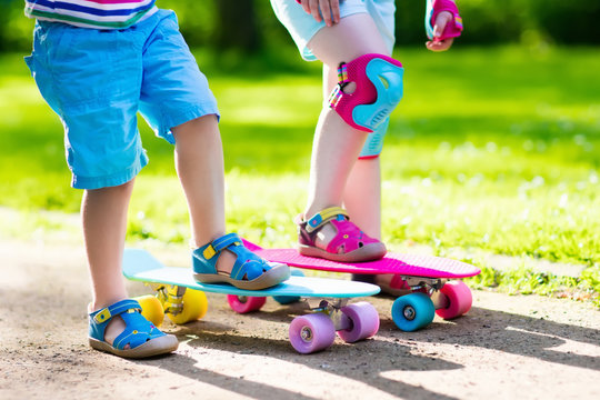 Children riding skateboard in summer park