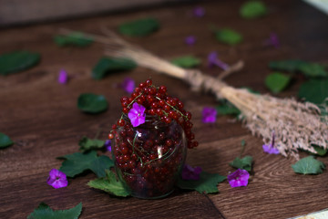 Berries of a currant in a glass jar on a wooden background.