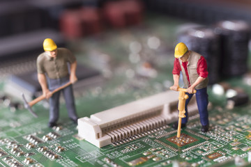 Miniature Workers On Top Of Circuit Board