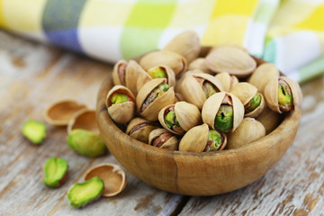 Healthy snack: pistachio nuts in wooden bowl, closeup
