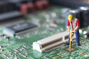 Miniature Worker Drilling On Top Of Circuit Board