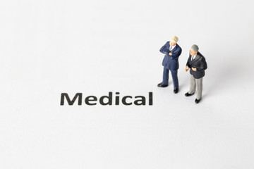 Miniature model of businessman standing with medical wording. People with agreement concept.