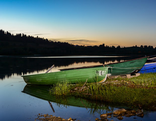 Fototapeta na wymiar Illuminated rowboats at a lake at night