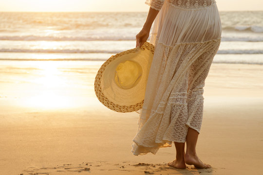 Woman wearing beautiful white dress on the beach