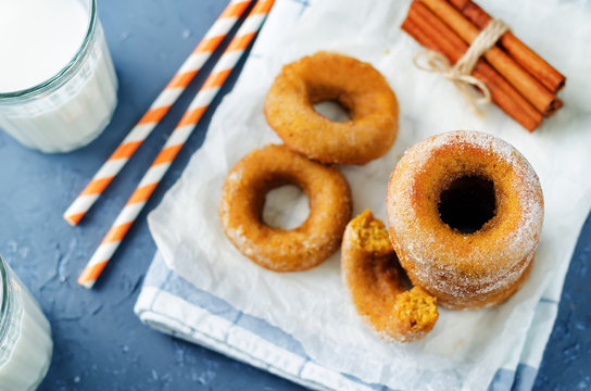 Baked pumpkin donuts with glasses of milk