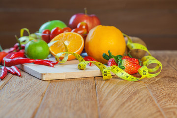 Healthy concept with mixed fruits and vegetables on wooden background