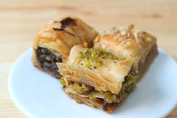 Closed up three types of Baklava with pistachios and nuts served on white plate, with selective focus 