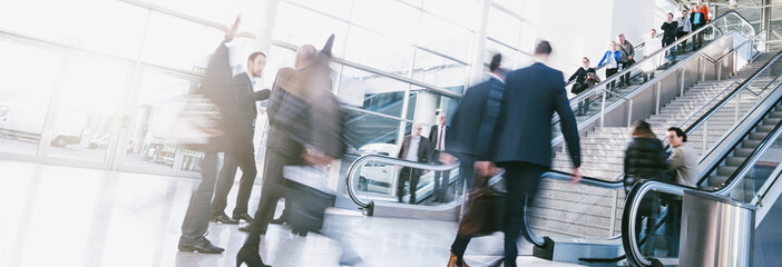 crowds of people in motion blur on a trade fair