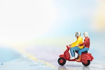 Aluminium Prints Scooter Travel Concept. Group of traveler miniature figures ride motorcycle / scooter on world map.