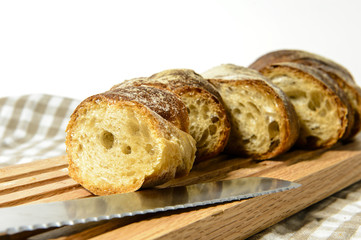 Brotscheiben auf Eichebrett, Brotmesser im Vordergrund