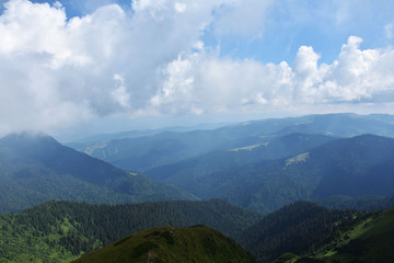 Fototapeta premium Clouds over mountains, mountain ranges, summer tourism