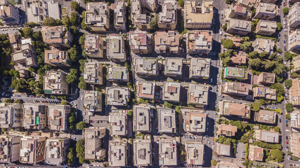 Vista aerea ortogonale di una parte del quartiere Monteverde a Roma. Tra le strade strette e i palazzi si vedono alberi e tanto verde mentre sugli edifici antenne e parabole.