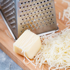 Grated parmesan cheese on a wooden board. Cooking food.