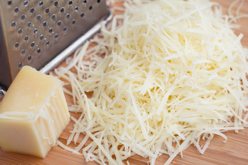 Grated parmesan cheese on a wooden board. Cooking food.