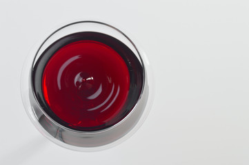 Wineglass with red wine on white background.