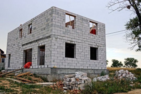 Стройплощадка  с недостроенным домом из белого кирпича