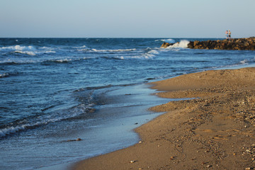 Beach with sea waves close-up in summertime. Greece, Crete