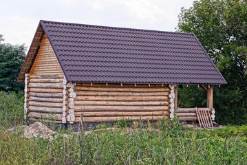 коричневый деревянный сельский домик из брёвен в саду