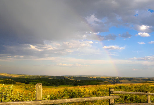 Faint Rainbow in the rainy skies over the alberta prairies and foothills at the Ranch