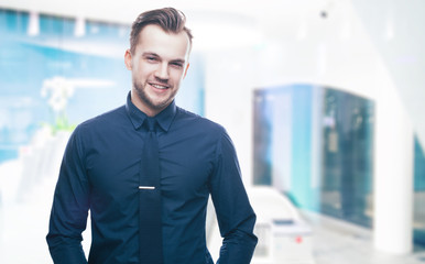 Handsome stylish young man in shirt looking at the camera. Office worker. Business decisions. Beautiful light background