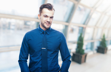 Handsome stylish young man in shirt looking at the camera. Office worker. Business decisions. Beautiful light background