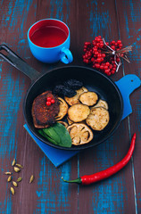 Roasted beef steak with eggplant and prunes. Meat dishes. Vegetables with meat. Wooden board rustic