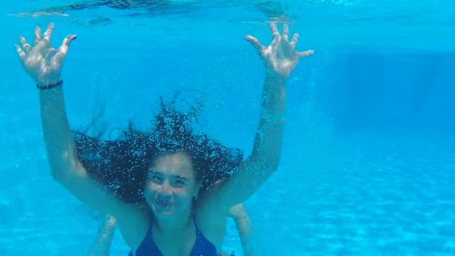 Beautiful girl under the water. A girl waving her hands under the water.